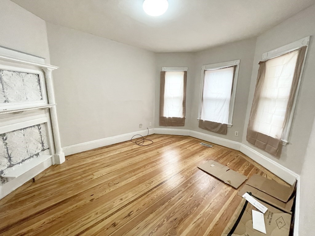 10 Wave Avenue, Unit 1 Boston, MA 02125 - Photo 3 of 9 a view of an empty room with wooden floor and a window