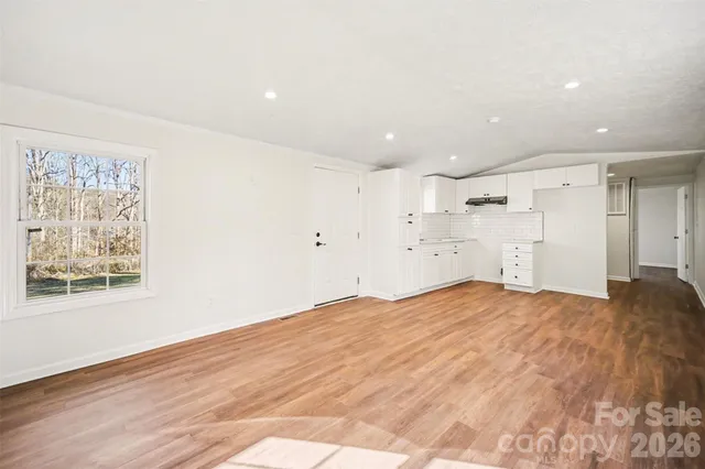 a view of empty room with wooden floor and window