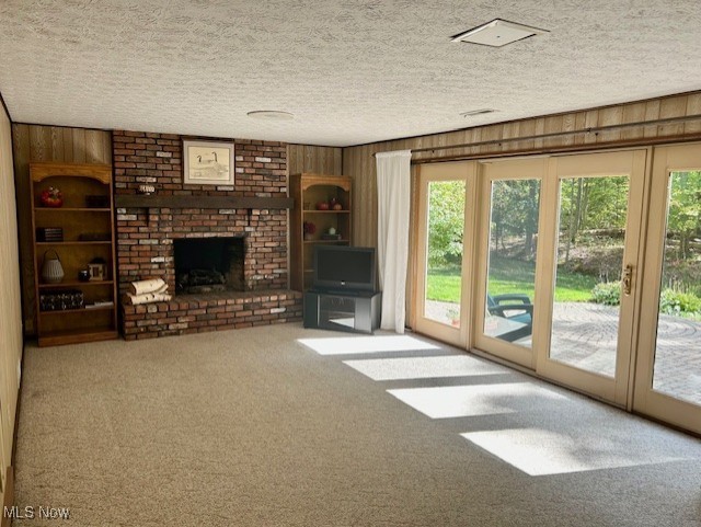 3422 Southern Road Richfield, OH 44286 - Photo 18 of 42 Unfurnished living room featuring a brick fireplace, a textured ceiling, wood walls, and carpet flooring