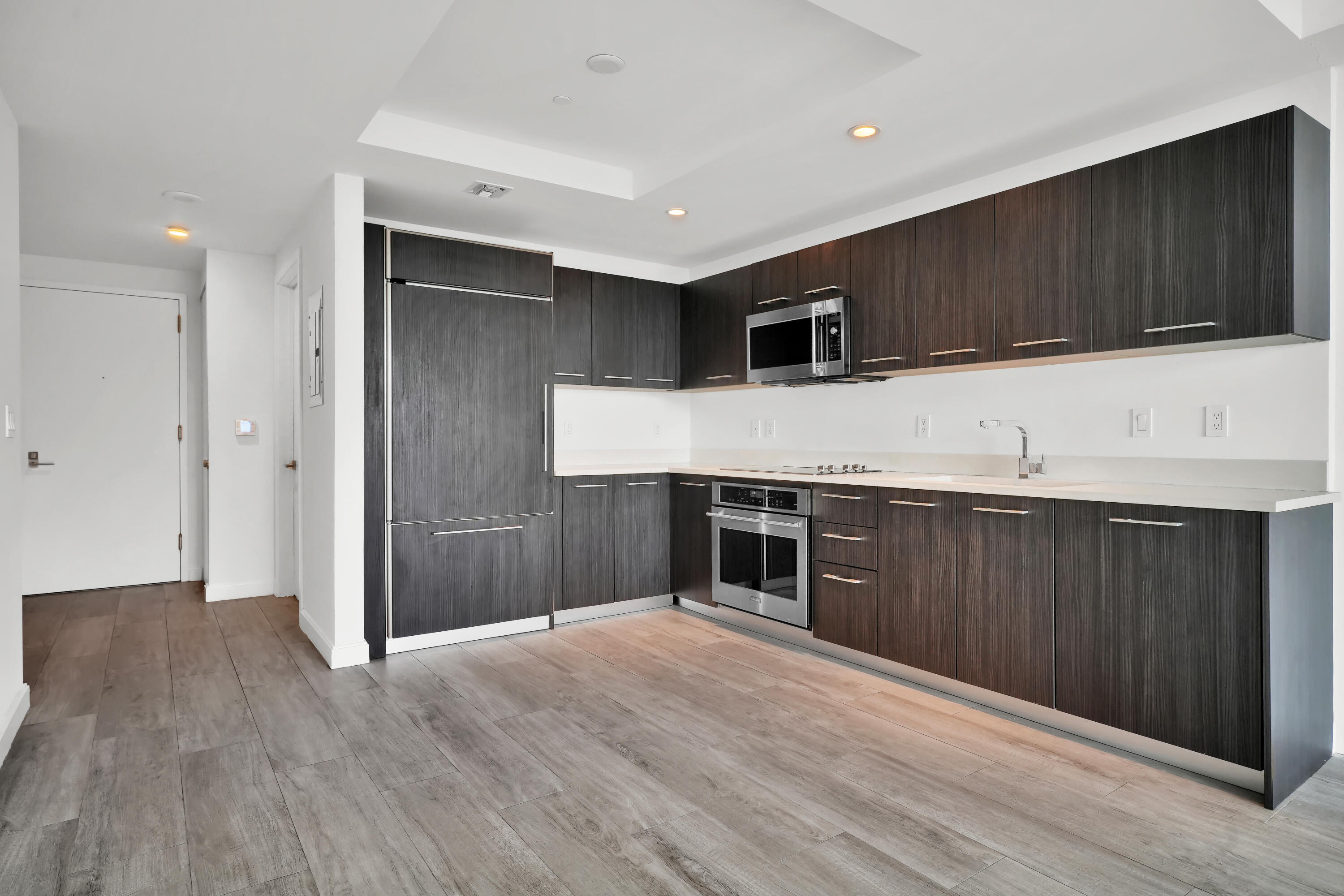 55 Southwest 9th Street, Unit 3504 Miami, FL 33130 - Photo 6 of 33 a kitchen with stainless steel appliances kitchen island granite countertop a refrigerator oven a sink with wooden cabinets and floors