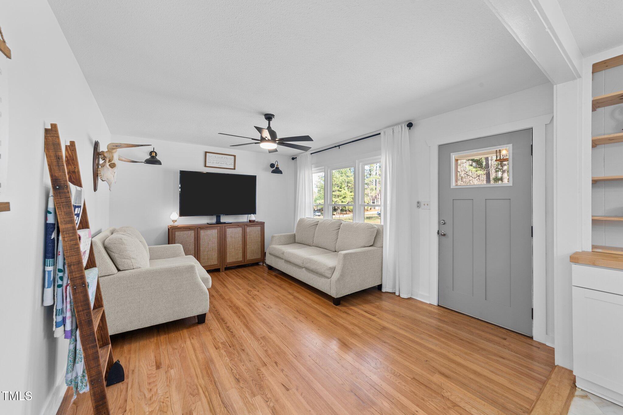4775 Barber Mill Road Clayton, NC 27520 - Photo 26 of 54 a living room with furniture and a flat screen tv