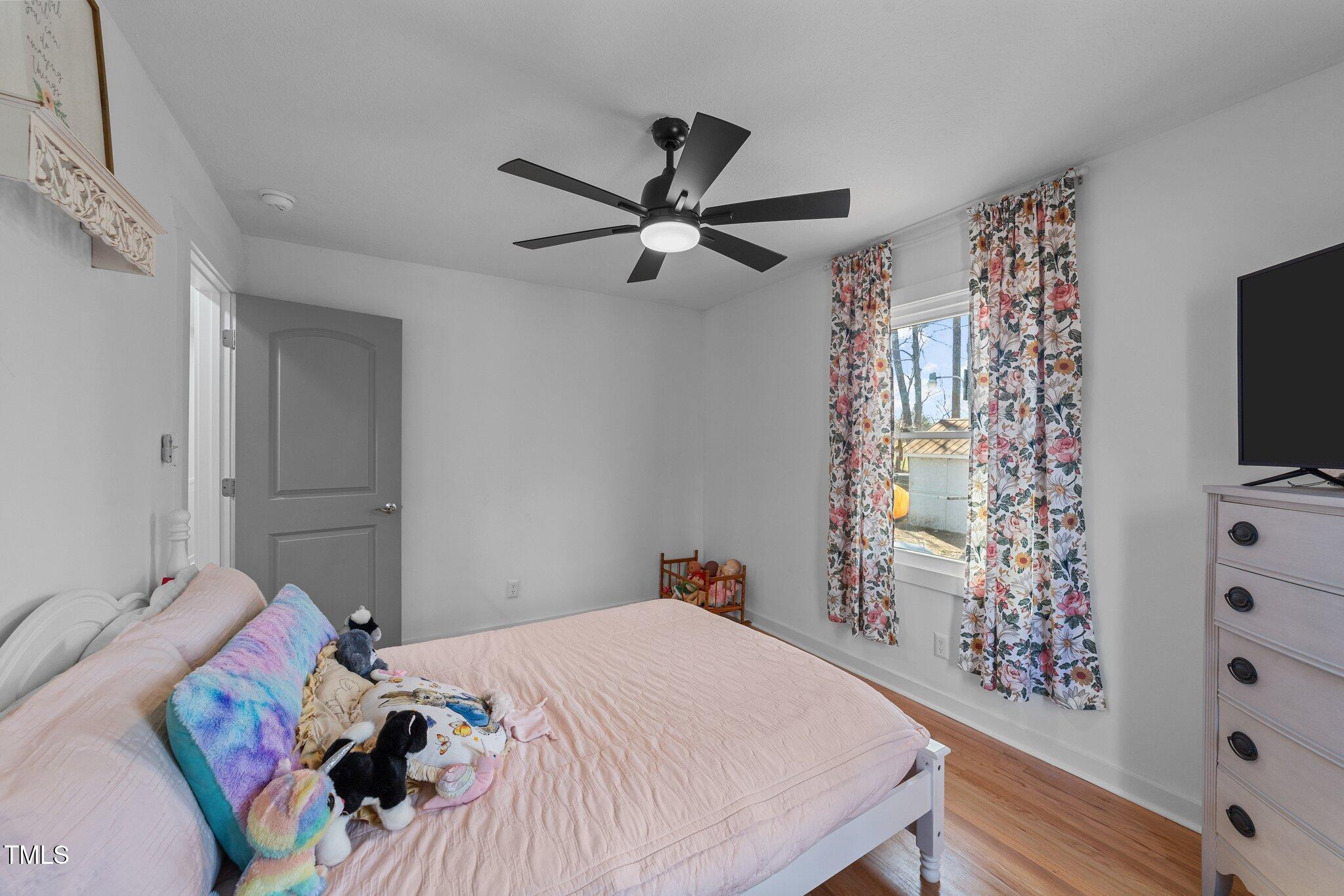 4775 Barber Mill Road Clayton, NC 27520 - Photo 50 of 54 a bedroom with a bed and a flat tv screen on dresser