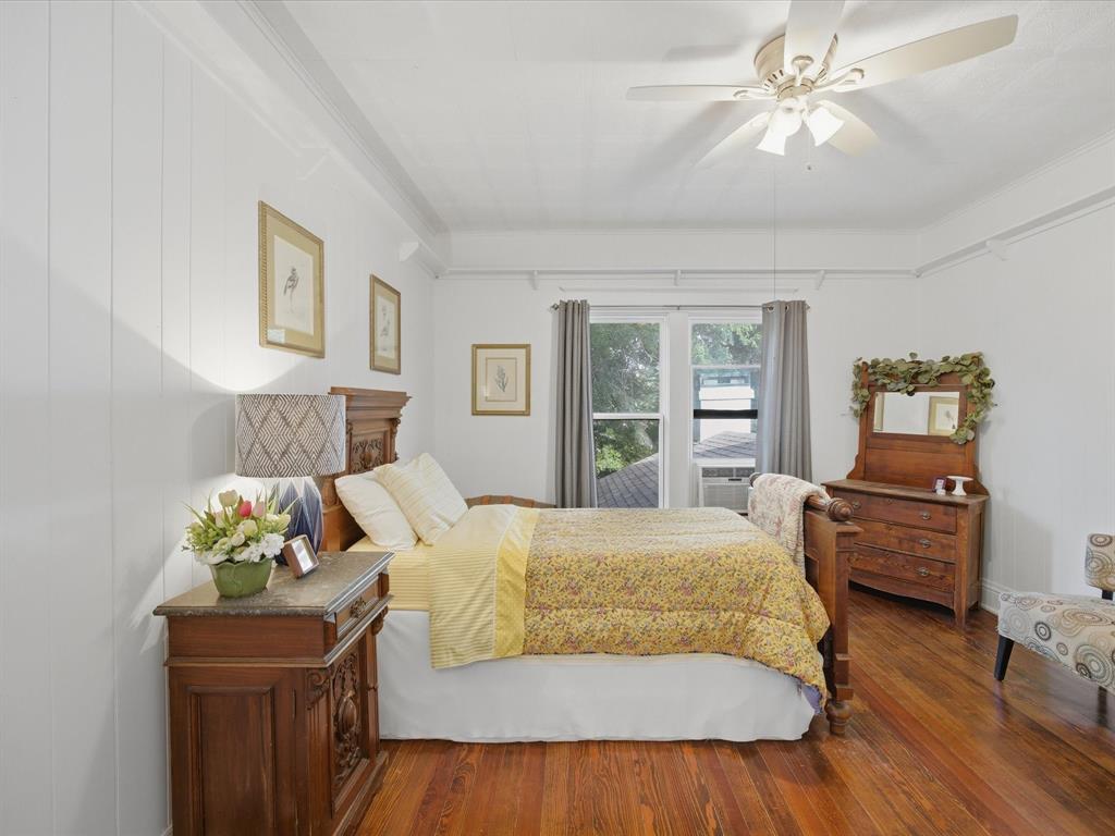 907 4th Street Graham, TX 76450 - Photo 19 of 34 a bedroom with a bed dresser and wooden floor