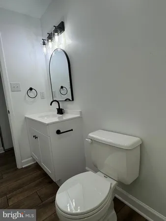 a bathroom with a toilet a sink and mirror