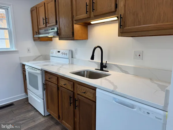 a kitchen with stainless steel appliances granite countertop a sink stove and cabinets