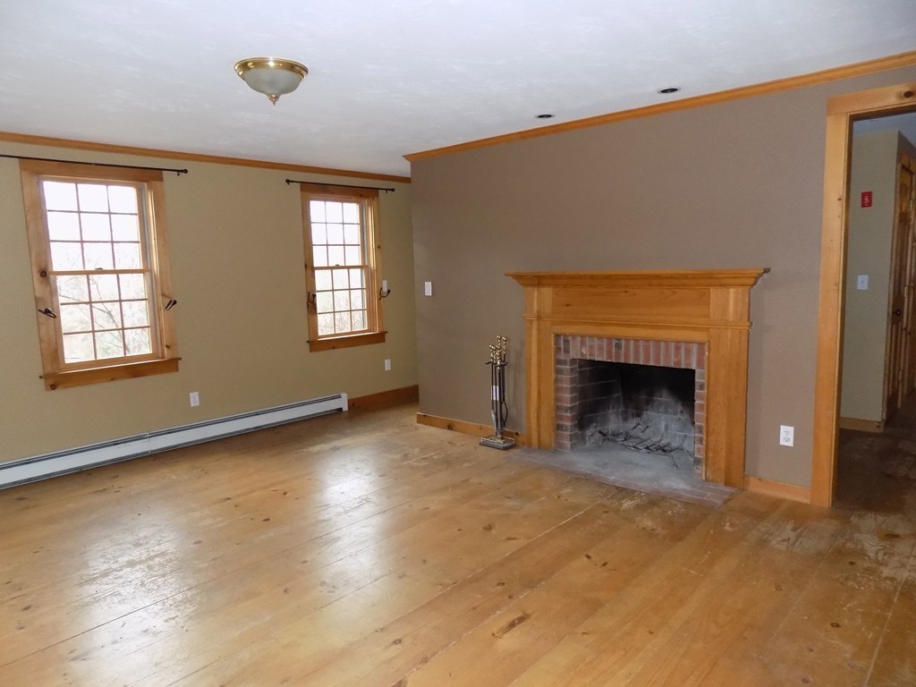 176 Crouch Road Warren, MA 01092 - Photo 6 of 19 an empty room with windows and fireplace