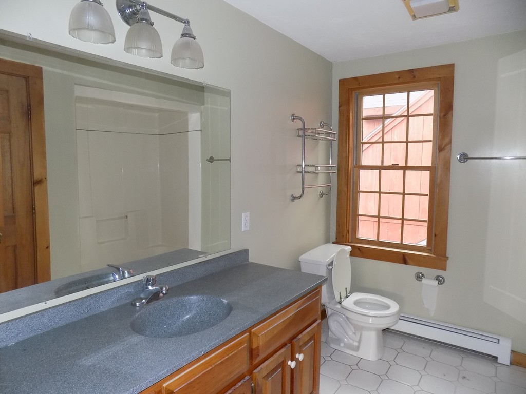 176 Crouch Road Warren, MA 01092 - Photo 10 of 19 a bathroom with a granite countertop sink a toilet and a window