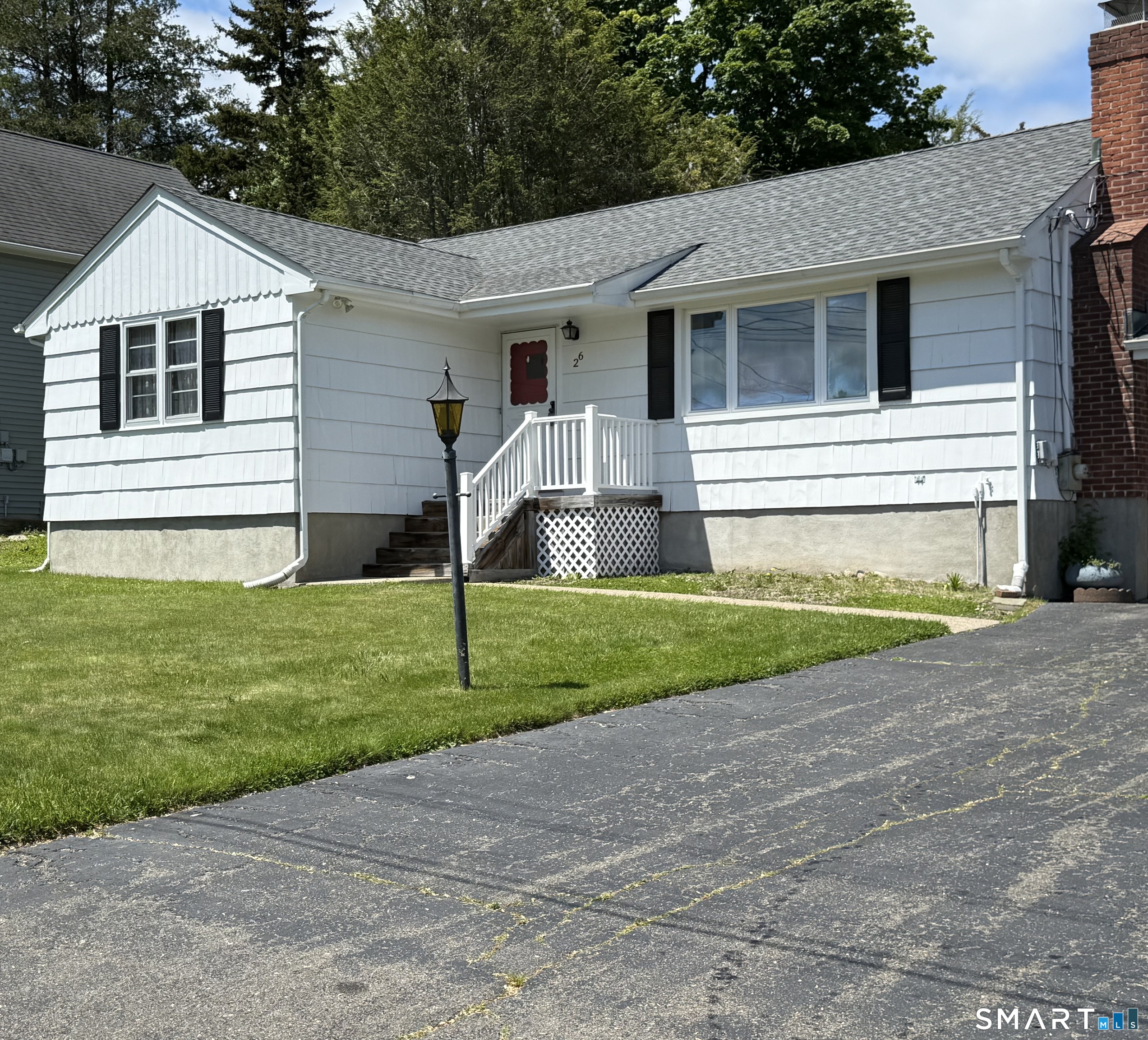 26 Maple Street Trumbull, CT 06611 - Photo 2 of 37 a view of a white house next to a yard and large trees