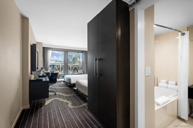 a bedroom with two beds and large windows