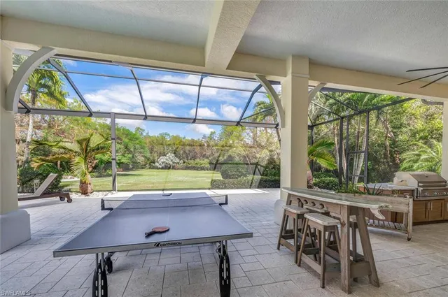 a view of a patio with a table and chairs under an umbrella with a large tree