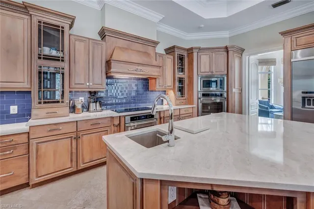 a kitchen with granite countertop a sink a stove and cabinets
