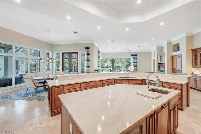 a kitchen with stainless steel appliances granite countertop a sink and chairs