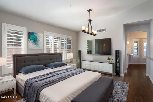 a bedroom with a large bed and a flat tv screen