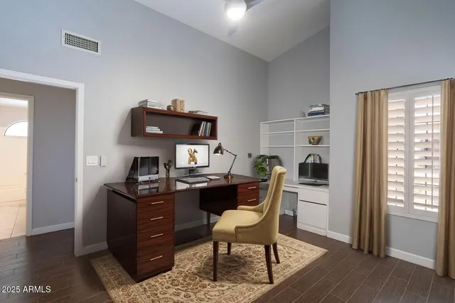 a view of a workspace with furniture and a window