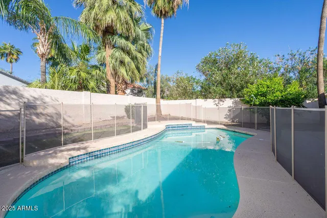 a view of house with swimming pool and sitting area