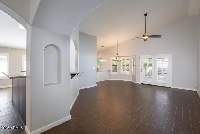 a view of an empty room with window and wooden floor