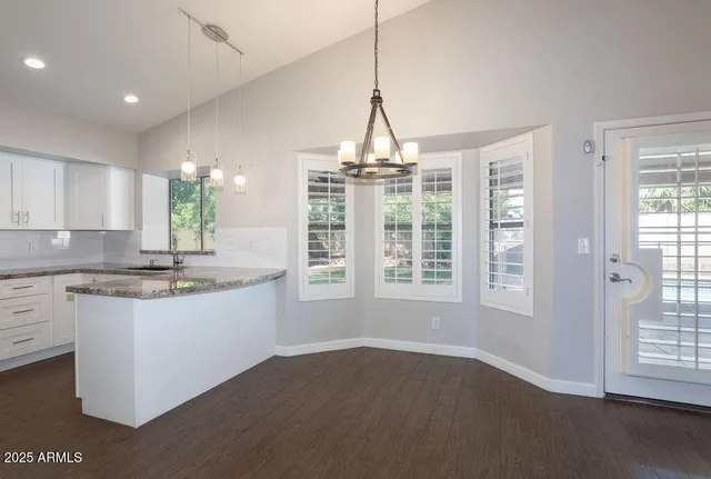 a kitchen with stainless steel appliances granite countertop a stove a sink and a window