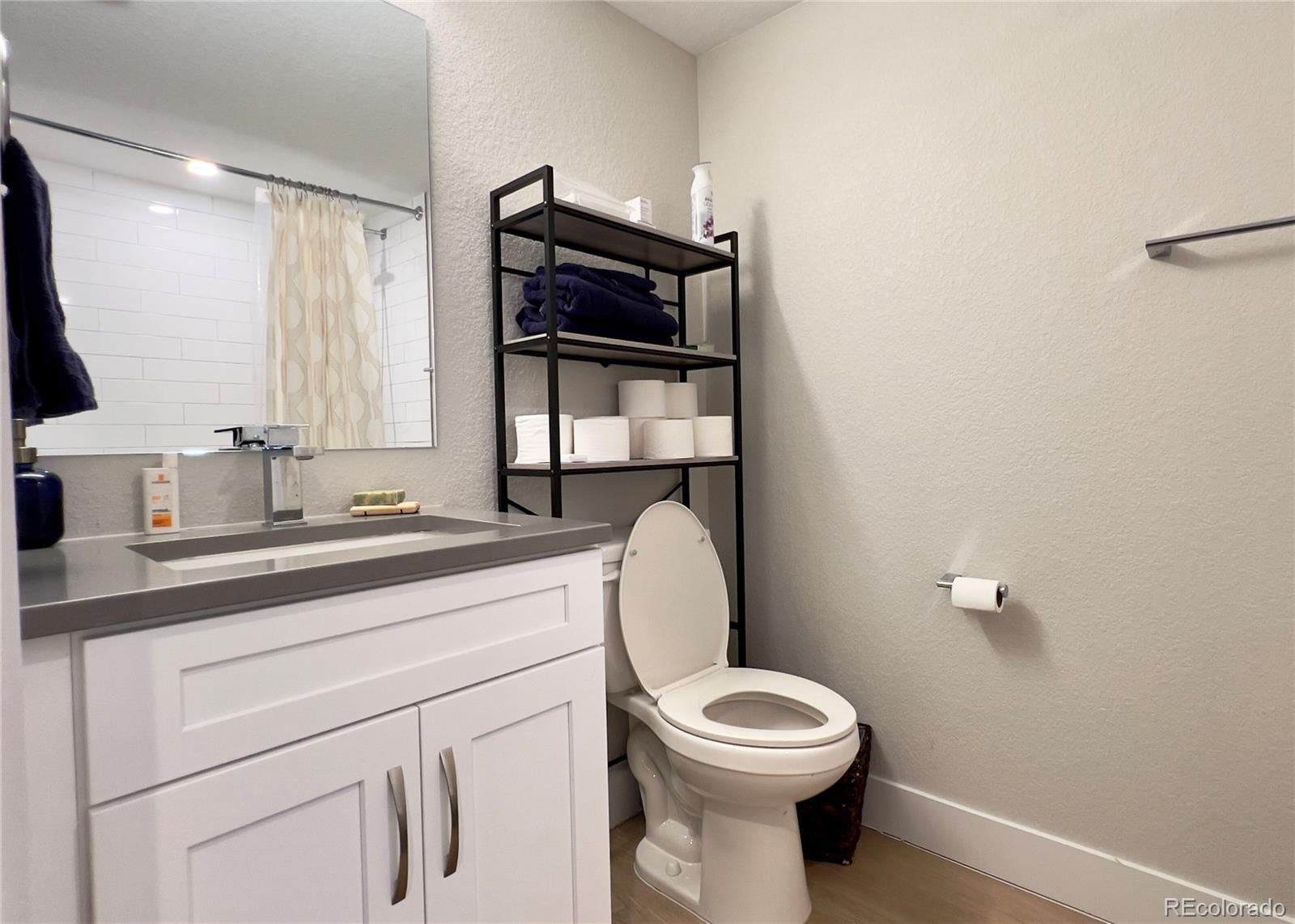 6228 West 38th Avenue Wheat Ridge, CO 80033 - Photo 28 of 38 a bathroom with a toilet a sink and mirror