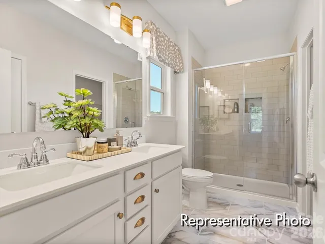 a bathroom with a granite countertop sink a mirror a bathtub and shower