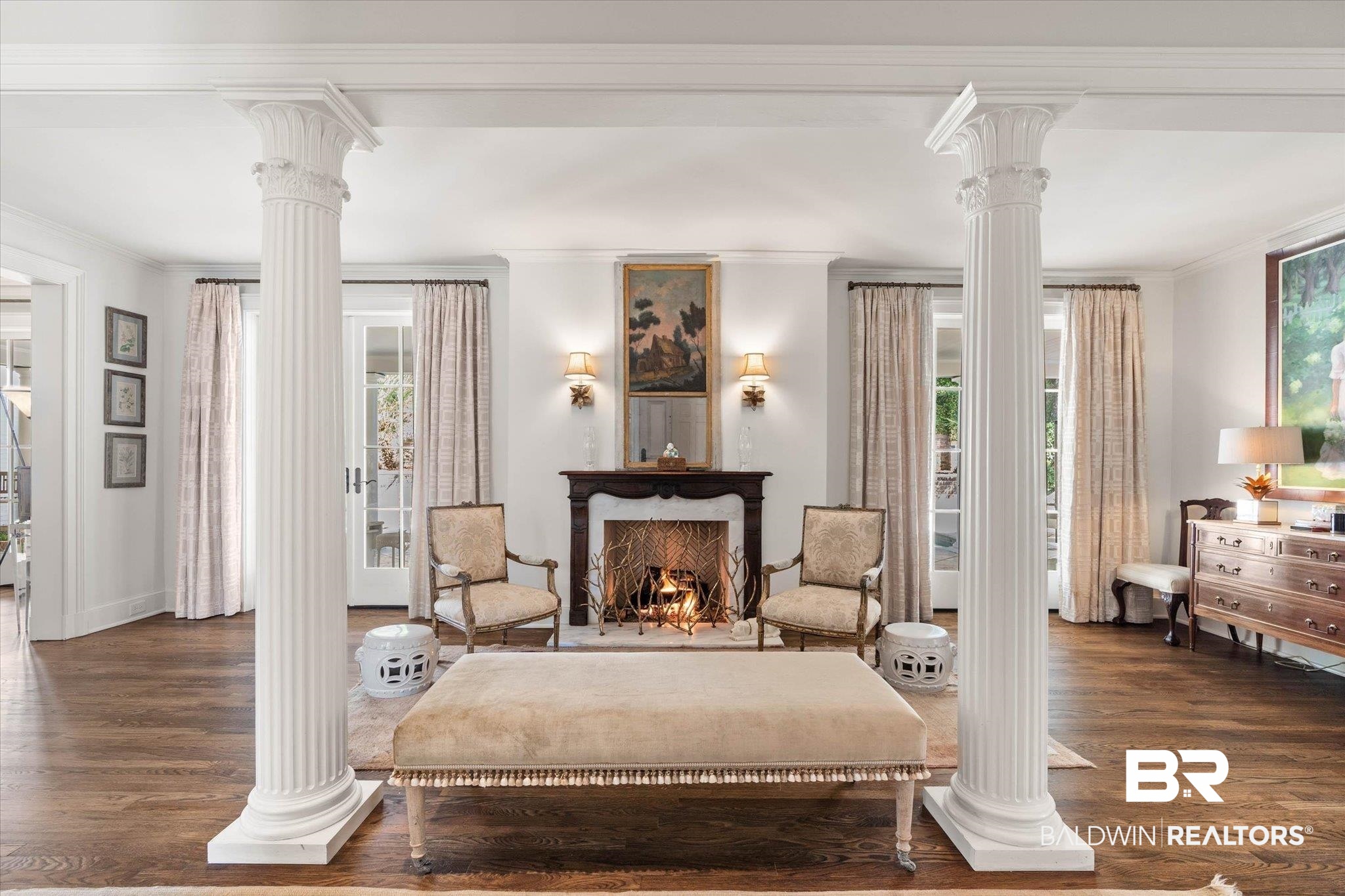 2256 De Leon Avenue Mobile, AL 36607 - Photo 3 of 61 Living area featuring decorative columns, ornamental molding, dark wood finished floors, plenty of natural light, and a warm lit fireplace