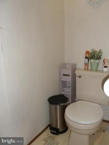 a white toilet sitting next to a white sink and vanity