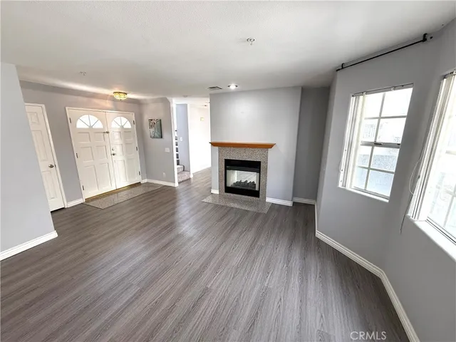 an empty room with wooden floor and fireplace