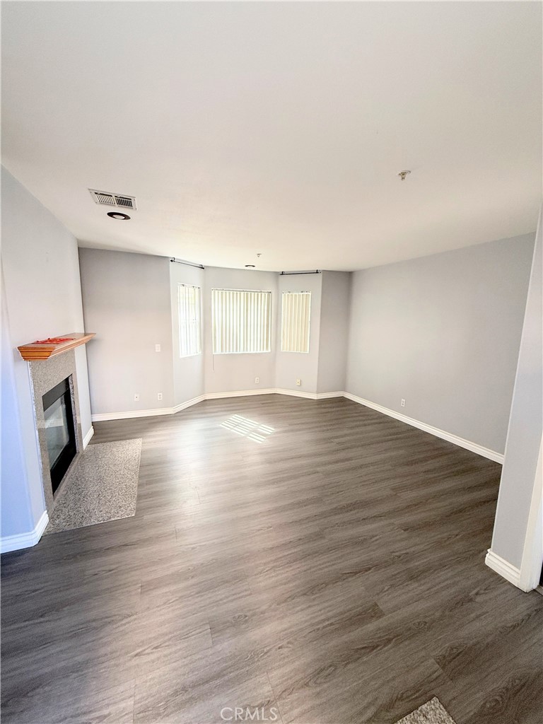 1230 Elm Avenue, Unit G San Gabriel, CA 91775 - Photo 6 of 33 an empty room with wooden floor and fireplace