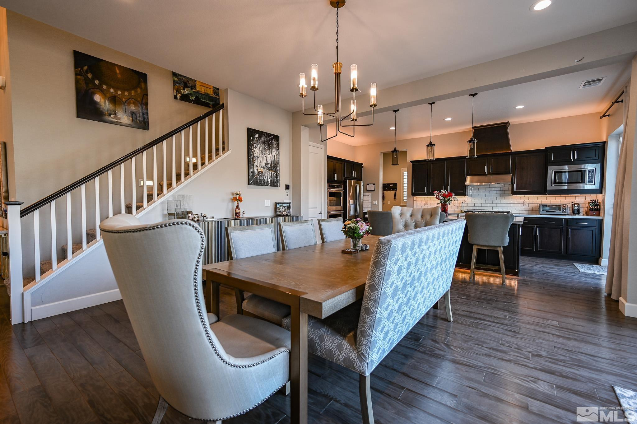 9330 Mayfair Way Reno, NV 89521 - Photo 12 of 40 a dining room with wooden floor a chandelier a wooden table and chairs