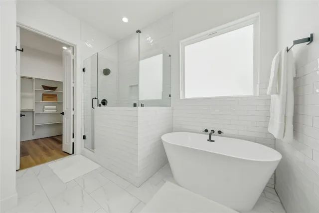 a bathroom with a white tub shower sink and mirror