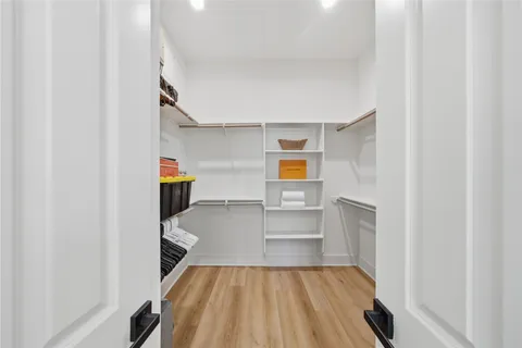 a view of storage and utility room with wooden floor and chair