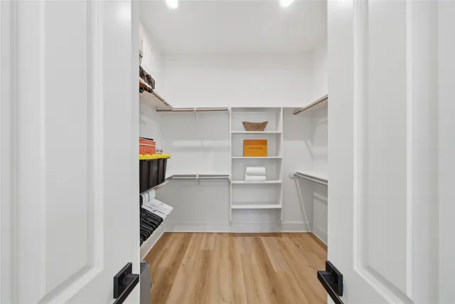 a view of storage and utility room with wooden floor and chair