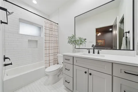 a bathroom with a toilet a sink a tub and mirror