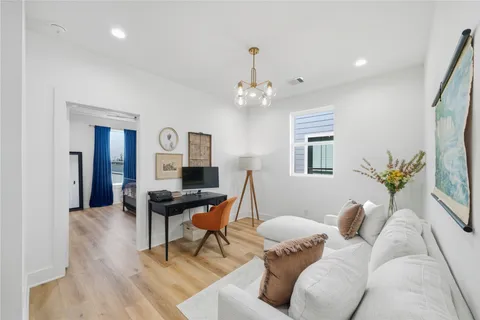 a living room with furniture a chandelier and a dining room