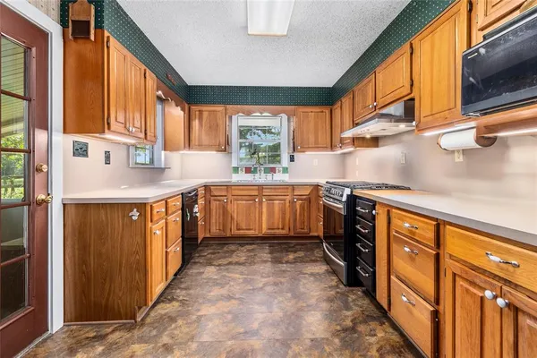 a kitchen with stainless steel appliances granite countertop a sink and a stove