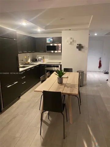 a kitchen with a table chairs microwave and cabinets