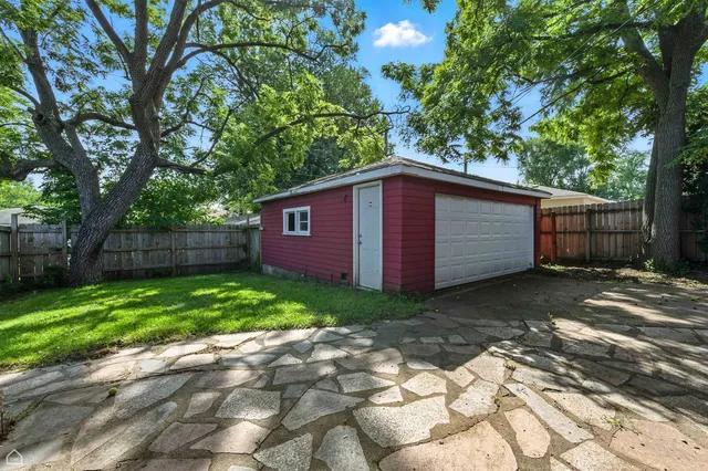 a view of a backyard with barn plants and large tree