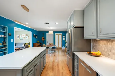 a kitchen with stainless steel appliances granite countertop a sink a stove top oven a counter space and cabinets