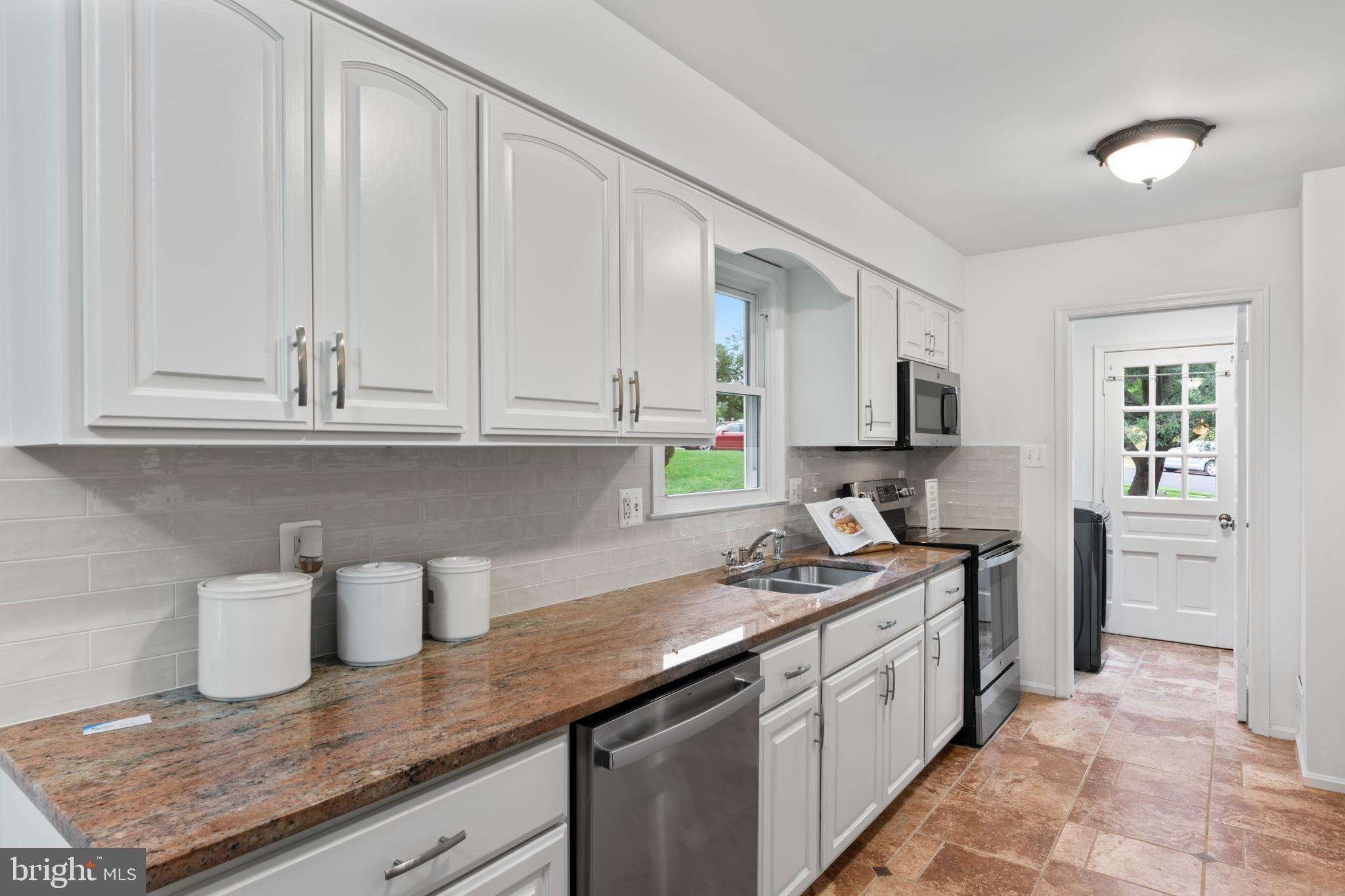 1950 Weybridge Lane Reston, VA 20191 - Photo 16 of 71 a kitchen with stainless steel appliances granite countertop a sink stove and cabinets
