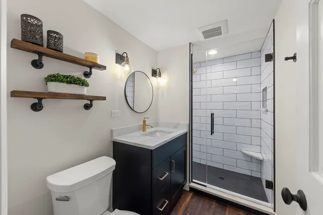 a bathroom with a sink a toilet and shower