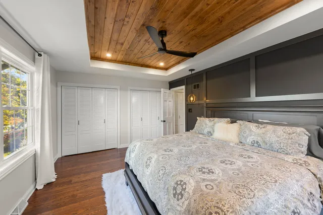 a bedroom with a large bed and wooden floor