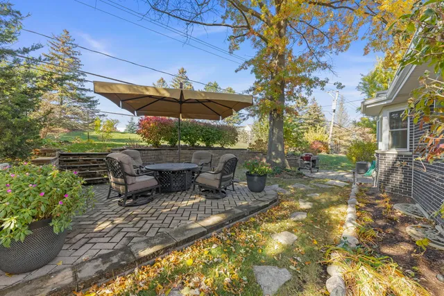 a view of a patio with a table and chairs under an umbrella