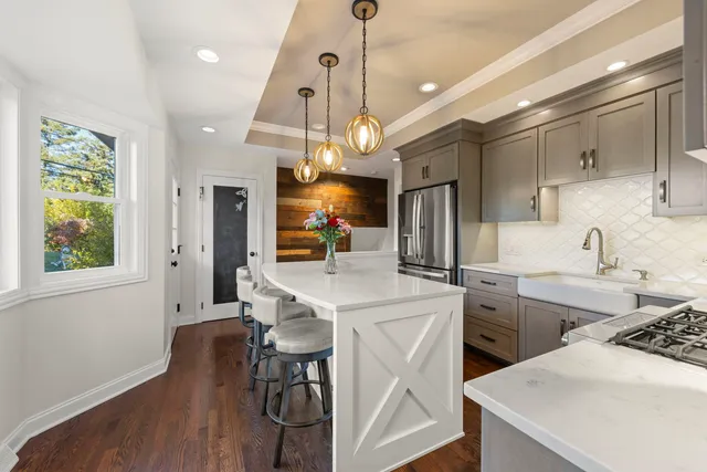 a kitchen that has a lot of cabinets in it and wooden floor