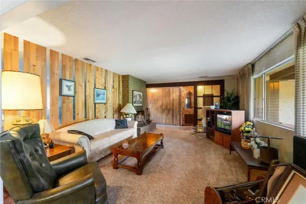 a living room with furniture flat screen tv and a large window