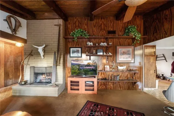a living room with furniture a flat screen tv and a large window