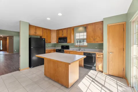 a kitchen with stainless steel appliances kitchen island granite countertop a refrigerator stove top oven and sink