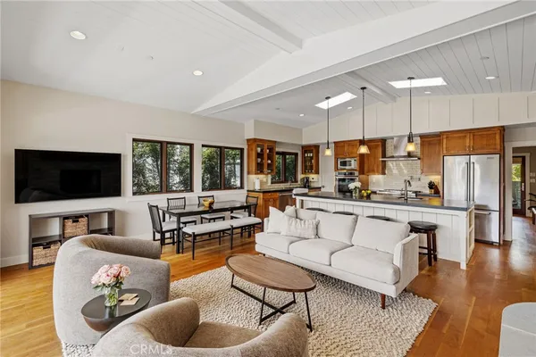 a living room with furniture kitchen view and a large window