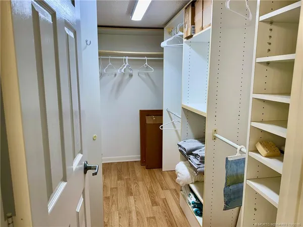 a view of walk in closet with empty racks