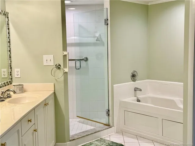 a bathroom with a tub sink vanity and a mirror
