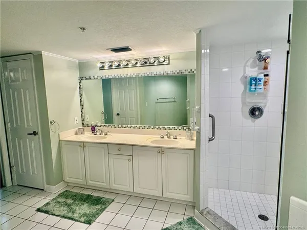 a bathroom with a sink shower and a mirror