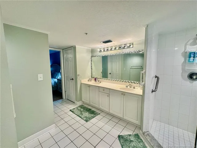 a bathroom with a sink mirror and a shower